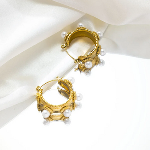 Close-up of a gold-plated baroque-style earring with freshwater pearls on model's ear