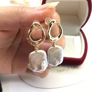 Baroque freshwater pearl drop earrings with gold abstract stud design in a velvet gift box.