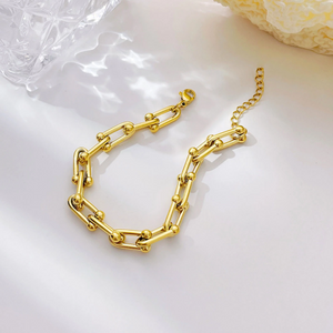 Gold chain bracelet on a light background