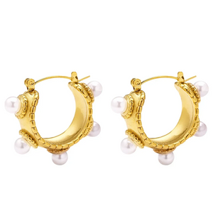 Close-up of a gold-plated baroque-style earring with freshwater pearls on model's ear