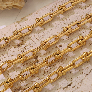 Gold chain on a textured beige surface