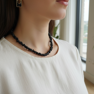 Black onyx gemstone necklace with matching gold-trimmed earrings on display.