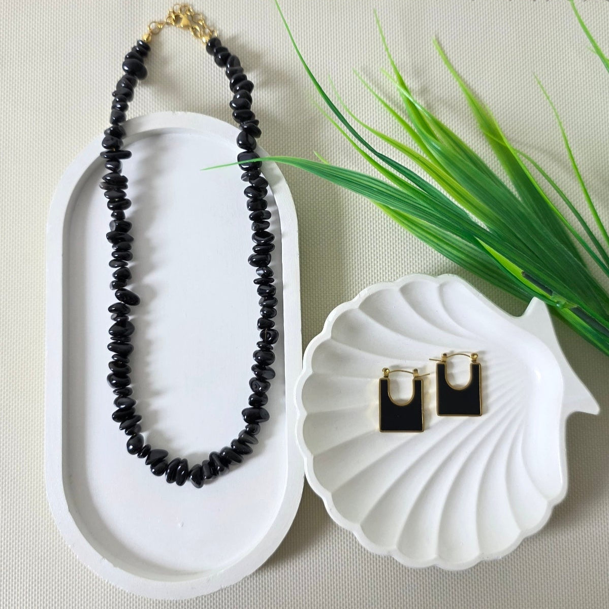 Black onyx gemstone necklace with matching gold-trimmed earrings on display.