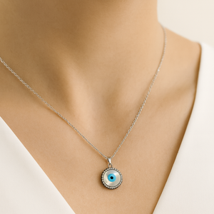 Necklace with a round pendant featuring an eye design on a mannequin.