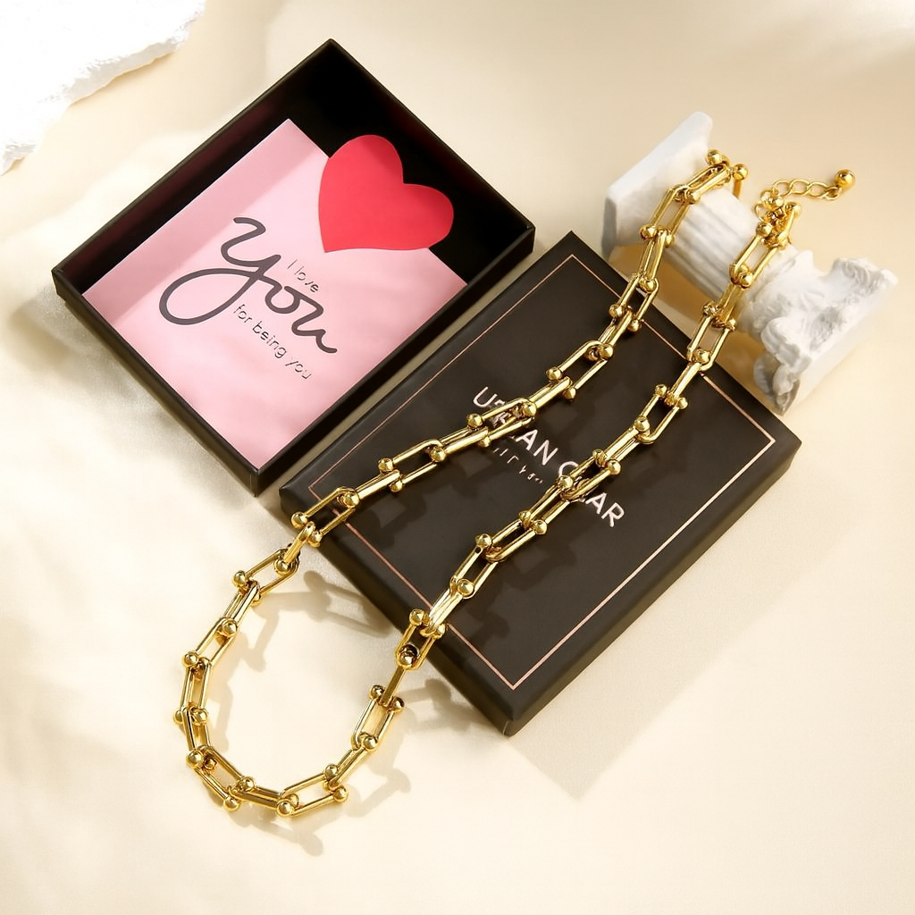Gold chain necklace on Urban Outfitters box with 'I love you' card