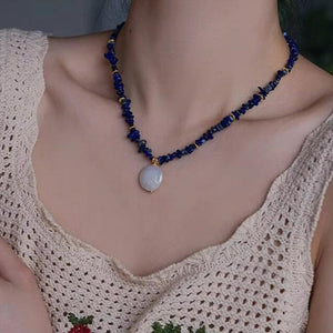 Woman wearing elegant baroque freshwater pearl pendant necklace with blue lapis lazuli chip beads