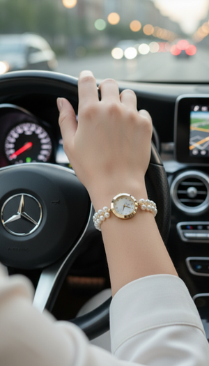 Hand with a watch on a car steering wheel, indicating a person is driving.