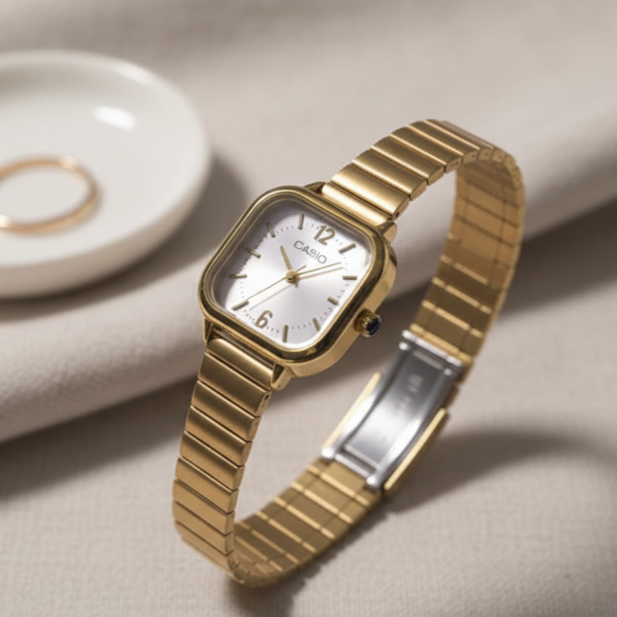 Gold Casio watch on a beige surface with a blurred background