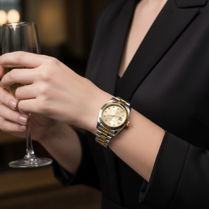 Person holding a glass of champagne wearing a gold watch in a blurred indoor setting