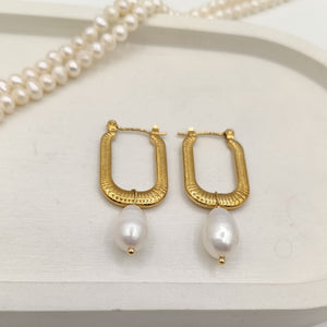 Gold-plated rectangular hoop earrings with freshwater pearls on display, luxury modern jewelry."