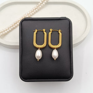 Gold-plated rectangular hoop earrings with freshwater pearls on display, luxury modern jewelry."