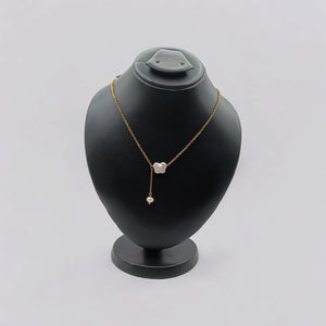 A delicate gold-plated necklace featuring a butterfly-shaped freshwater pearl pendant, styled on a soft fabric background.