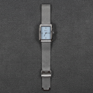 Silver watch with a mesh band on a gray textured background