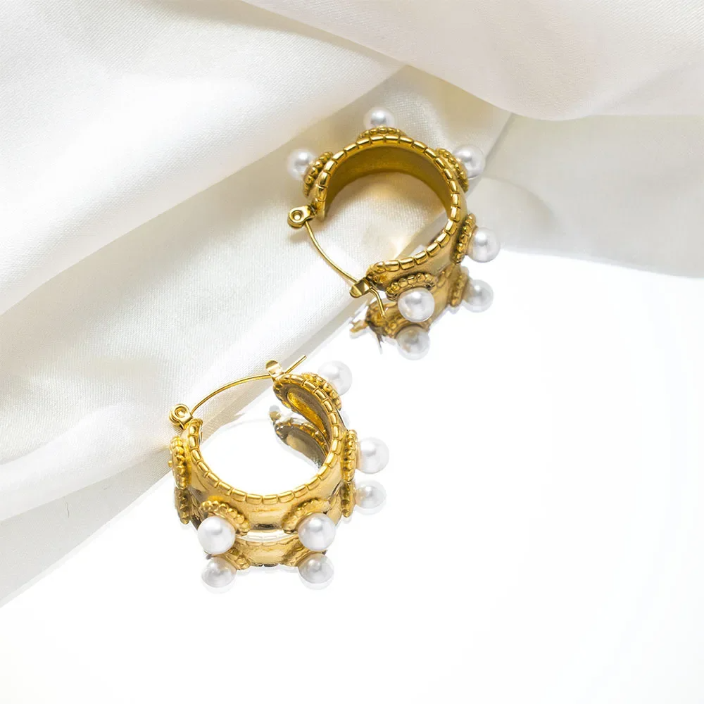 Close-up of a gold-plated baroque-style earring with freshwater pearls on model's ear