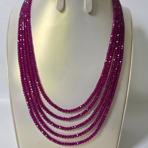 Purple beaded necklace on a white stand with a white background