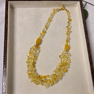 Necklace with yellow stones displayed in a box on a light background