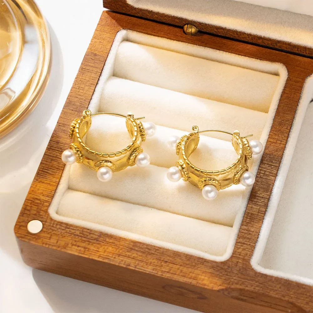 Close-up of a gold-plated baroque-style earring with freshwater pearls on model's ear