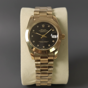 Gold wristwatch with black dial on a gray background