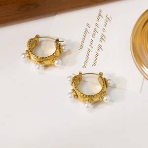 Close-up of a gold-plated baroque-style earring with freshwater pearls on model's ear