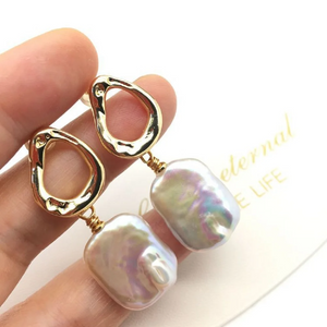 Baroque freshwater pearl drop earrings with gold abstract stud design in a velvet gift box.