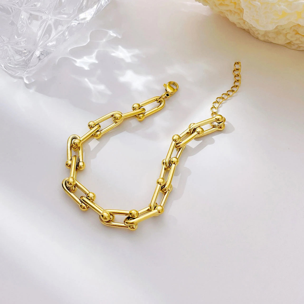 Gold chain bracelet on a light background