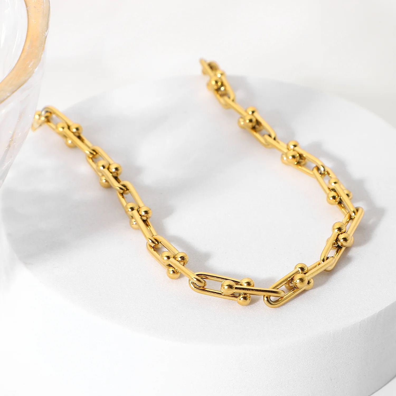 Gold chain bracelet on a white surface