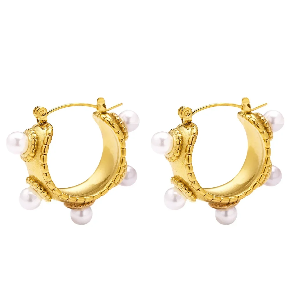 Close-up of a gold-plated baroque-style earring with freshwater pearls on model's ear