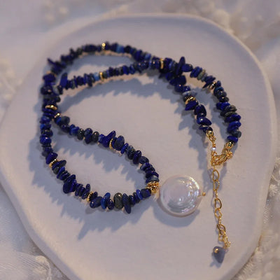 Woman wearing elegant baroque freshwater pearl pendant necklace with blue lapis lazuli chip beads