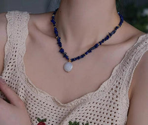 Woman wearing elegant baroque freshwater pearl pendant necklace with blue lapis lazuli chip beads