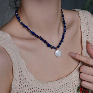 Woman wearing elegant baroque freshwater pearl pendant necklace with blue lapis lazuli chip beads