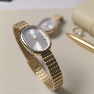 Gold watch with a white face on a light surface