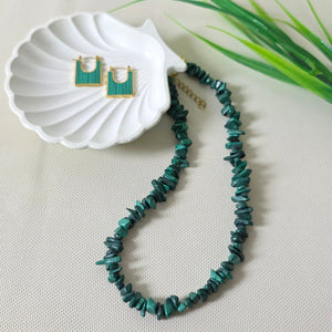 Bracelet with green beads on a white shell against a light background