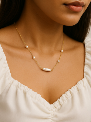 Pearl necklace worn by a person with a white top