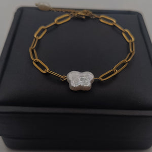 18K gold-plated chain bracelet with a natural freshwater pearl butterfly charm, displayed on a white jewelry stand.