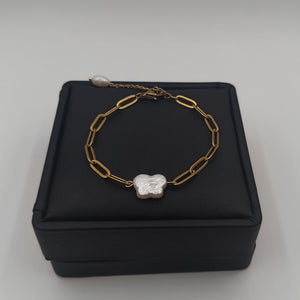 18K gold-plated chain bracelet with a natural freshwater pearl butterfly charm, displayed on a white jewelry stand.