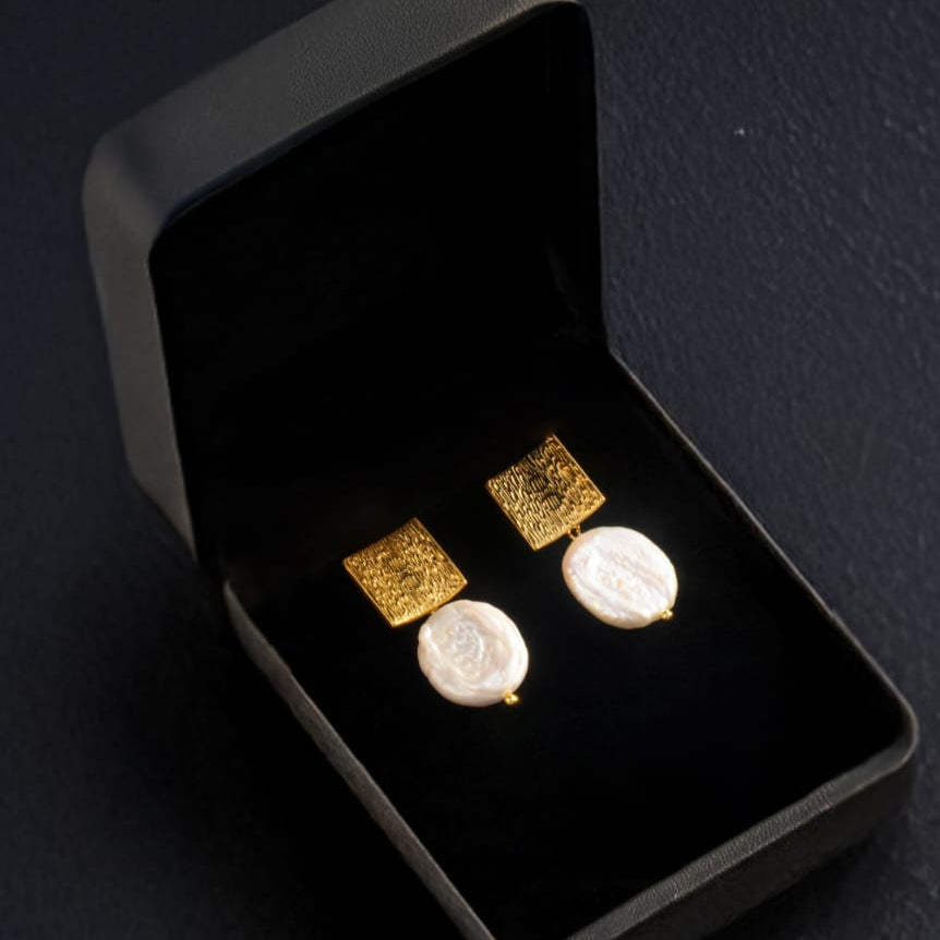 Square Earrings with Baroque Freshwater Pearls displayed on a black jewelry box."

