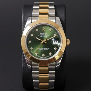 Luxury watch with green dial and two-tone metal band on a dark background