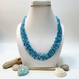 Close-up of polished blue jade gemstone beads forming a layered mala.