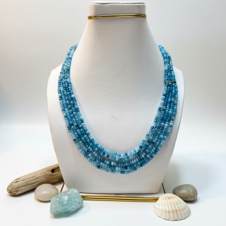 Close-up of polished blue jade gemstone beads forming a layered mala.