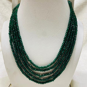 Green beaded necklace on a white mannequin bust