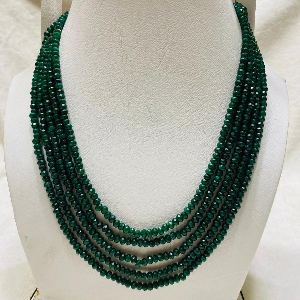 Green beaded necklace on a white mannequin bust