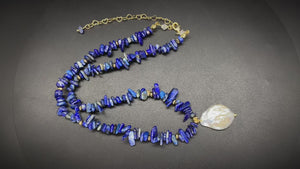 Woman wearing elegant baroque freshwater pearl pendant necklace with blue lapis lazuli chip beads