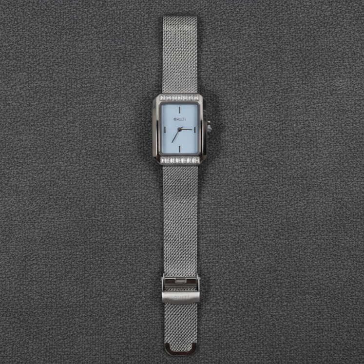 Silver watch with a mesh band on a gray textured background