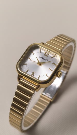 Gold Casio watch on a beige background