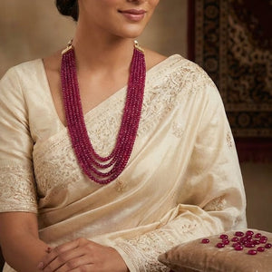 Multi-strand ruby beads necklace with faceted shine displayed on jewelry stand
